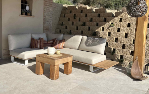 Gemütlicher Außenbereich mit beigem Sofa, Holztisch und Kissen bei Brezza di sera agriturismo - Glampingtenten Le Marche.