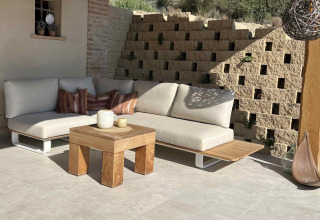 Udendørs loungeområde med beige sofa, træbord og dekorative puder på Brezza di sera agriturismo Glampingtenten Le Marche.