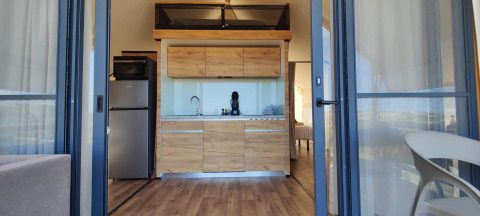 Moderne indretning i glampingtelt hos Brezza di sera agriturismo, Le Marche, med køkken og soveområde.