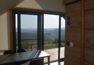 Interieur van Brezza di sera agriturismo glampingtent met uitzicht op de heuvels van Le Marche.