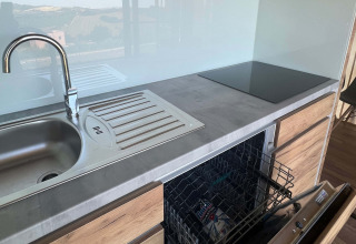 Cocina moderna con fregadero, lavavajillas y placa de cocina en Brezza di Sera Glamping en Le Marche.