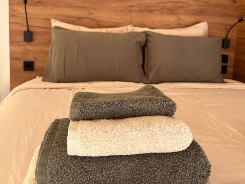 Stack of soft towels on a cozy bed in Brezza di sera agriturismo - Glampingtenten Le Marche glamping site.