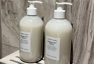 To flasker [comfort zone] Tranquillity shampoo og shower gel på badeværelseshylde i Brezza di sera Glampingtenten, Le Marche.