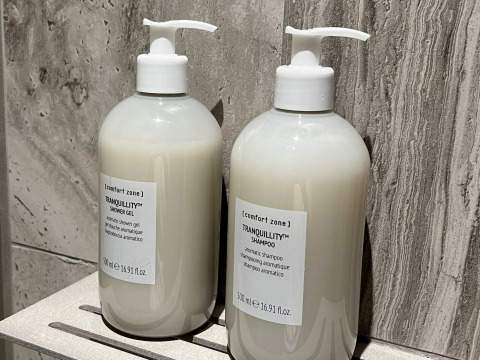 Twee flessen [comfort zone] Tranquillity shampoo en douchegel op plank bij Brezza di sera Glampingtenten, Le Marche.