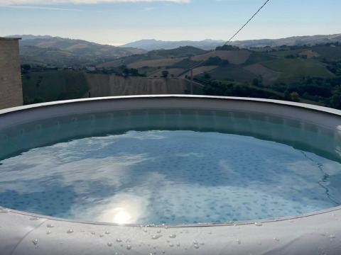 Vasca idromassaggio con vista sulle colline presso Brezza di sera agriturismo - Glampingtenten Le Marche.