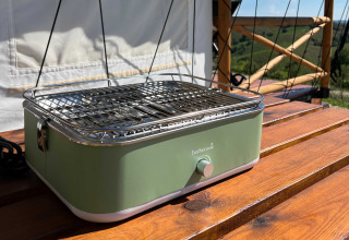 Groene draagbare barbecue op houten terras bij Brezza di sera agriturismo - Glampingtenten Le Marche, glamping.