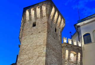 Oplyst middelaldertårn ved skumring i Le Marche, Italien, tæt på Brezza di sera agriturismo glamping.