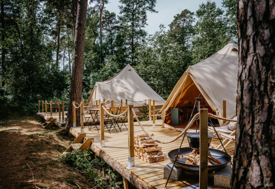 Glampingaccommodatie bij Nordic Woods - Wildernis Glamping Zweden met tenten en houten terras in het bos.