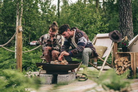 Stel geniet van bosglamping bij Nordic Woods - Wildernis Glamping Zweden met vuur en ontspanning.