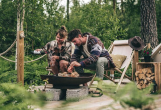 Stel geniet van bosglamping bij Nordic Woods - Wildernis Glamping Zweden met vuur en ontspanning.