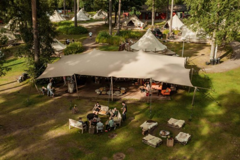 Luchtfoto van Nordic Woods - Wildernis Glamping Zweden met glampingtenten, gezamenlijke ruimte en natuur.