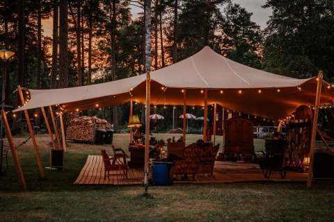 Glamping Nordic Woods - Wildernis Glamping Zweden met verlicht tentdoek en sfeervol ingericht in het bos.
