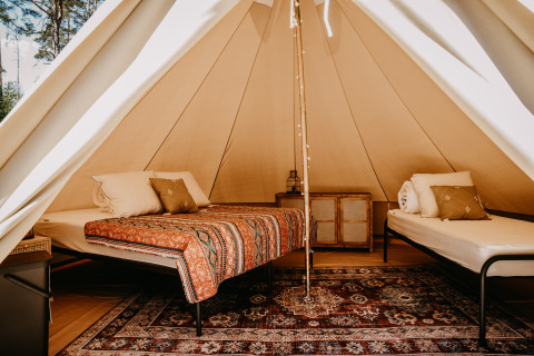 Sfeervolle glamping accommodatie bij Nordic Woods - Wildernis Glamping Zweden met comfortabele bedden en kleed.