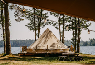 Glamping accommodatie in een tent bij een meer in Zweden, omringd door bomen, Nordic Woods Wildernis.