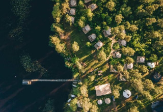 Luchtfoto van Nordic Woods - Wildernis Glamping Zweden met glamping tenten aan een bosrijk meer in Zweden.