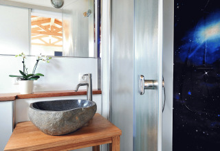 Baño moderno con lavabo de piedra y ducha en el glamping Zur Grünen Kutte - Zigeunerwagen Thüringen.