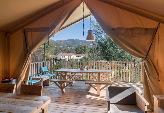 Luxuriöses Safarizelt mit Holzterrasse und Blick auf das grüne Umland bei Quinta do Cascalhal, Braga.