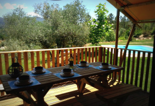 Træterrasse med spisebord og udsigt over pool og grøn natur hos Quinta do Cascalhal - Safaritenten Braga.