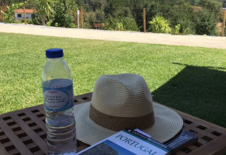 Vista su Quinta do Cascalhal - Safaritenten Braga con cappello, bottiglia d'acqua e guida di viaggio Portogallo.