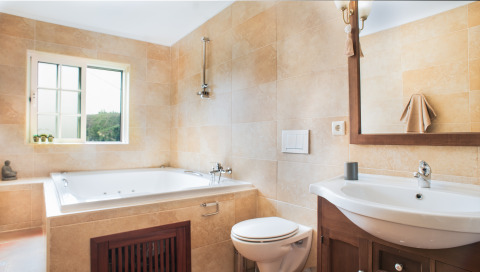 Bright bathroom at Quinta do Cascalhal - Safaritenten Braga with bathtub, toilet, sink and large mirror.