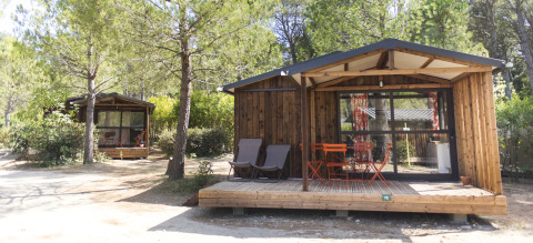 Glamping indkvartering ved Huttopia Fontvieille i Provence med træhytter mellem træerne og solrige terrasser.