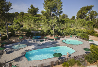 Huttopia Fontvieille – Glamping Provence avec piscines extérieures, bains de soleil et parasols en pleine forêt.