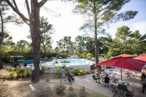 Piscina al aire libre y zona de terraza con árboles en Huttopia Fontvieille – Glamping Provence camping.