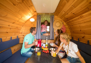 Familie beim Entspannen und Essen in einem Weinfass auf dem Camping im Bergischen Land, Nordrhein-Westfalen.