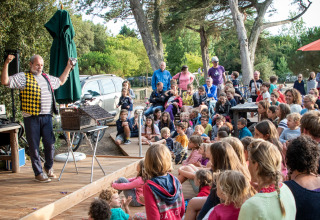 Outdoor show with a clown entertaining children and families at Huttopia Noirmoutier - Glamping Vendée.