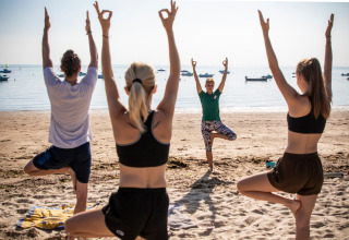 Yoga ved stranden på Huttopia Noirmoutier - Glamping Vendée med udsigt over havet og afslappet stemning.