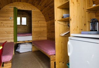 Vista interior de glamping en Camping Markelfingen en el lago Constanza, con camas y frigorífico.