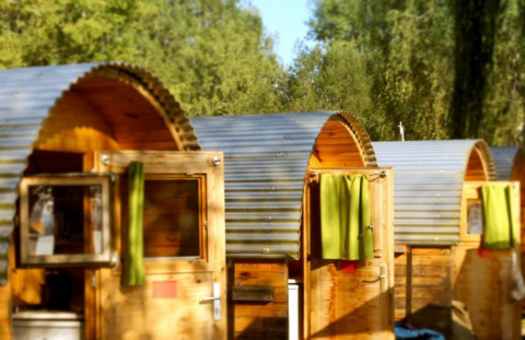 Billedet viser hyggelige campinghytter med runde tage og grønne gardiner ved Camping Markelfingen.