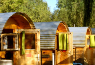 De foto toont glamping slaapvaten met ronde daken en groene gordijnen bij Camping Markelfingen aan de Bodensee.