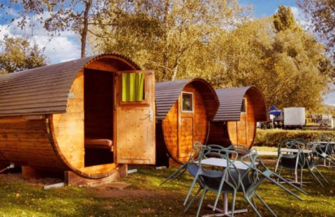Glamping accommodation at Camping Markelfingen with barrel cabins and outdoor seating area by Lake Constance.