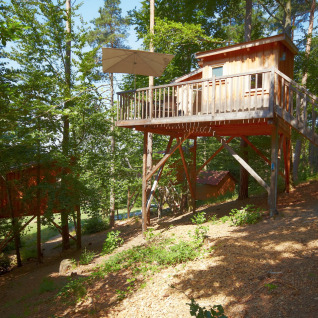 Glamping-Baumhaus-Unterkunft im Baumpalast Boomhutten, Baden-Württemberg, mitten im Wald mit Terrasse.