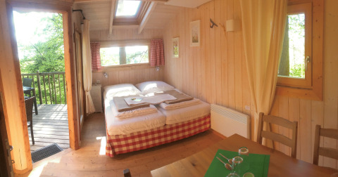 Hyggelig trækabine-glamping med dobbeltseng, træinteriør og en terrasse med udsigt, Baumpalast Boomhutten.