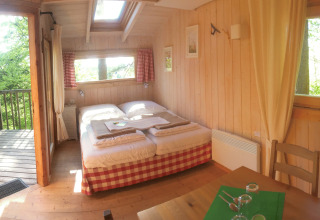 Hyggelig trækabine-glamping med dobbeltseng, træinteriør og en terrasse med udsigt, Baumpalast Boomhutten.