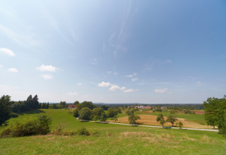 Blick auf sanfte Hügel, Felder und Dorf bei Baumpalast Boomhutten Glamping in Baden-Württemberg, Deutschland.
