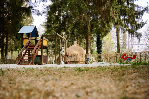 Parco giochi e tenda tipì immersi nel bosco a Camping de Marcourt - Tipitenten in Lussemburgo belga.