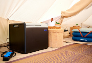 Intérieur d’une tente glamping au Camping de Marcourt avec glacière, matelas gonflable et décoration.