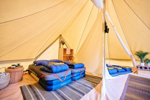 Intérieur de tente glamping confortable avec lits et déco moderne au Camping de Marcourt, Luxembourg belge.