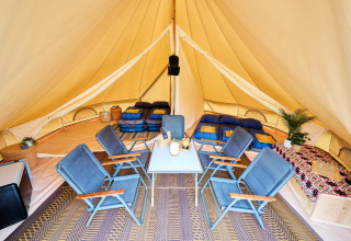 Innenansicht eines luxuriösen Tipi-Zelts mit Betten und Stühlen auf dem Camping de Marcourt in Belgisch Luxemburg.