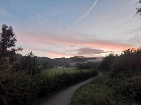 Sonnenaufgang über Feldern und Wald bei Camping de Marcourt - Tipitenten in Belgisch Luxemburg.