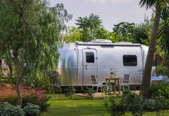 Alloggio glamping presso PROCIDA Camp & Resort con lussuoso Airstream immerso nel verde rigoglioso.