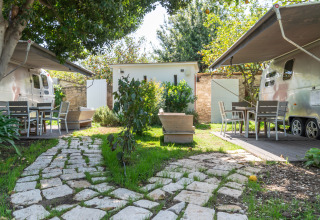 Glamping-Unterkunft im PROCIDA Camp & Resort mit luxuriösen Airstreams, Garten und Sitzbereichen.