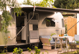 Airstream glamping accommodation at Procida Camp & Resort with outdoor seating area and awning shade.