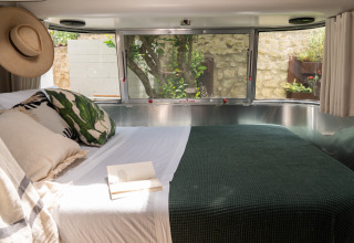 Indvendigt billede af luksuriøst indrettet airstream med dobbeltseng hos PROCIDA Camp & Resort.