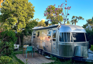 Hébergement glamping au PROCIDA Camp & Resort avec Airstream de luxe et espace extérieur aménagé.