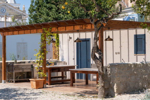 Buitenkeuken met houten pergola en zitplaatsen bij Procida Camp & Resort - Luxe airstreams.
