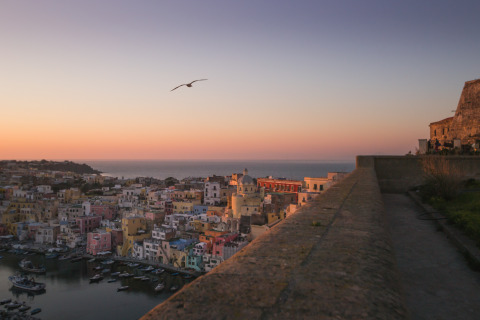 Vista al tramonto su case colorate e mare vicino a PROCIDA Camp & Resort - Luxe airstreams a Procida.
